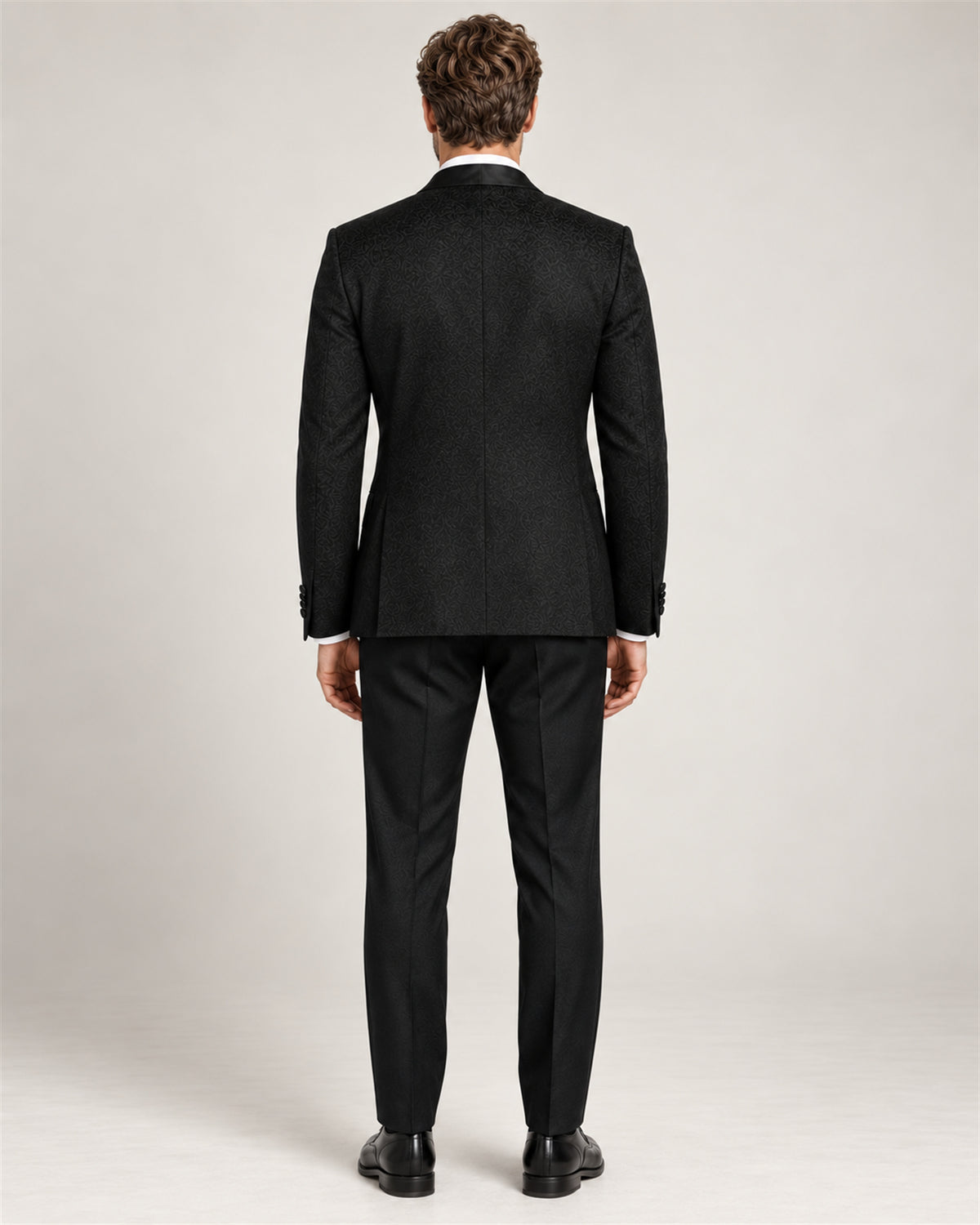 Black three-piece slim-fit tuxedo with a shawl collar – back view on model